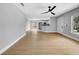 Open-concept living space with hardwood flooring, white walls, and a ceiling fan at 8504 N 17Th St, Tampa, FL 33604