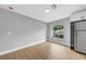 An open room featuring an exterior window, light wood flooring, and stainless steel refrigerator at 8504 N 17Th St, Tampa, FL 33604
