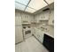 Efficient kitchen features white appliances, cabinets, and tile flooring for a bright and clean feel at 861 Maple Ct # 104, Dunedin, FL 34698