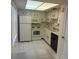 Efficient kitchen features white appliances and tile floors for a bright, clean, and functional space at 861 Maple Ct # 104, Dunedin, FL 34698