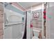 Bathroom featuring a shower with safety bars, a flamingo picture, and a rustic wood accent wall at 8931 Blind Pass Rd # 360, St Pete Beach, FL 33706