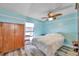Cozy bedroom offers natural light, wood-look floors, and a wooden wardrobe at 8931 Blind Pass Rd # 360, St Pete Beach, FL 33706