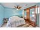 Bright bedroom features a wooden fan, wood-look floors, and ample storage with a large armoire at 8931 Blind Pass Rd # 360, St Pete Beach, FL 33706