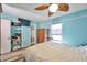 Bedroom features blue walls, wood-look floors, TV, and a wooden fan at 8931 Blind Pass Rd # 360, St Pete Beach, FL 33706