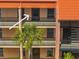 Exterior of the condo featuring a balcony with black railings and a tropical palm tree at 8931 Blind Pass Rd # 360, St Pete Beach, FL 33706