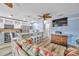 Open-concept living space with white cabinets, stainless appliances, and a cozy seating area at 8931 Blind Pass Rd # 360, St Pete Beach, FL 33706