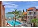 Beautiful waterfront pool area with lounge chairs and well-maintained landscaping surrounded by tropical palm trees and boats at 8931 Blind Pass Rd # 360, St Pete Beach, FL 33706