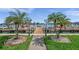 Scenic waterfront dock featuring palm trees, a walkway, and boat slips at 8931 Blind Pass Rd # 360, St Pete Beach, FL 33706