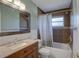 Well-lit bathroom features a single sink vanity, shower-tub combo, and neutral wall and tile at 9240 53Rd N Way, Pinellas Park, FL 33782