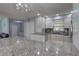 Well-lit kitchen with white cabinetry, granite countertops, and a modern chandelier at 9240 53Rd N Way, Pinellas Park, FL 33782