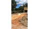 Landscaped backyard features a fire pit, lake views, and a wooden deck for relaxing and enjoying the outdoor space at 10040 Lake Dr, Weeki Wachee, FL 34613