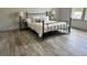Bedroom features a sleek black metal bed frame, complementing light wood-look flooring at 10040 Lake Dr, Weeki Wachee, FL 34613