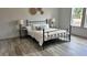Bedroom features a sleek black metal bed frame, complementing light wood-look flooring at 10040 Lake Dr, Weeki Wachee, FL 34613
