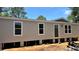New single-story home featuring a neutral exterior, white-trimmed windows, and a front door, set against a bright blue sky at 10040 Lake Dr, Weeki Wachee, FL 34613