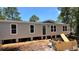 New single-story home featuring a neutral exterior, white-trimmed windows, and a front door, set against a bright blue sky at 10040 Lake Dr, Weeki Wachee, FL 34613