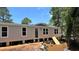 New single-story home featuring a neutral exterior, white-trimmed windows, and a front door, set against a bright blue sky at 10040 Lake Dr, Weeki Wachee, FL 34613