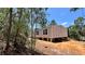 Exterior view of a modern home with light siding and white-framed windows, surrounded by trees at 10040 Lake Dr, Weeki Wachee, FL 34613
