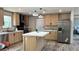 Bright kitchen with stainless steel refrigerator, large island and light wood cabinets at 10040 Lake Dr, Weeki Wachee, FL 34613