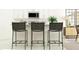 Kitchen island with three black weave bar stools, white countertops, cabinets, and stainless steel microwave at 10289 Gentle Rain Dr, Land O Lakes, FL 34638