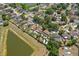 Neighborhood aerial showcasing lovely homes, green spaces, and a tranquil pond, surrounded by lush trees and landscaping at 10310 Salisbury St, Riverview, FL 33569