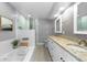 Bright bathroom featuring double vanity, soaking tub, and a glass-enclosed shower at 10310 Salisbury St, Riverview, FL 33569