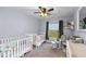 Charming Bedroom with soft colors, two cribs, and a comfortable glider for a serene atmosphere at 10310 Salisbury St, Riverview, FL 33569