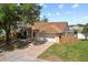 Attractive single-story house with a brick driveway, a two-car garage, and a fenced yard with mature trees at 10310 Salisbury St, Riverview, FL 33569