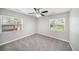 Bright bedroom featuring plush carpeting, a ceiling fan, and natural light from two windows at 105 N Comet Ave, Clearwater, FL 33765
