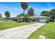 Single-story home with well-maintained lawn, long driveway, palm trees, and a one-car garage at 105 N Comet Ave, Clearwater, FL 33765