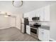 Kitchen featuring stainless steel appliances, white cabinetry, granite counters, and modern lighting at 105 N Comet Ave, Clearwater, FL 33765