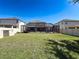 Large backyard with a screened-in patio, green lawn, and privacy fence at 10560 Lake Seminole Ter, Seminole, FL 33772
