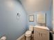 Powder room featuring wood-look floors, light blue walls, and a quaint sink cabinet at 10560 Lake Seminole Ter, Seminole, FL 33772