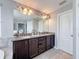 Bathroom with double sinks, granite counters, and dark wood cabinets at 10560 Lake Seminole Ter, Seminole, FL 33772