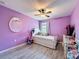 Bright bedroom featuring purple walls, white trim, and a window that brings in natural light at 10560 Lake Seminole Ter, Seminole, FL 33772