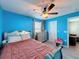Blue bedroom with wood-look floors, ceiling fan, and windows with a view at 10560 Lake Seminole Ter, Seminole, FL 33772