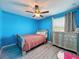 Bedroom with blue walls, wood-look flooring, and a silver dresser at 10560 Lake Seminole Ter, Seminole, FL 33772