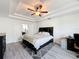 Spacious bedroom with gray floors, tray ceiling, and a ceiling fan at 10560 Lake Seminole Ter, Seminole, FL 33772
