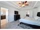 Bedroom showcasing wood-look floors, tray ceiling, and access to the bathroom at 10560 Lake Seminole Ter, Seminole, FL 33772