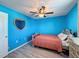 Bright bedroom features blue walls, wood flooring and a heart-shaped mirror at 10560 Lake Seminole Ter, Seminole, FL 33772