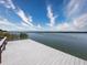Picturesque view of a wooden dock extending into the tranquil water under a partly cloudy sky at 10560 Lake Seminole Ter, Seminole, FL 33772
