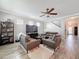 Inviting living room with comfortable leather seating, a ceiling fan, and wood-look floors, creating a cozy atmosphere at 10560 Lake Seminole Ter, Seminole, FL 33772