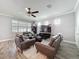 Cozy living room showcasing leather furniture, a ceiling fan, and natural light streaming through the window at 10560 Lake Seminole Ter, Seminole, FL 33772