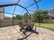 Screened-in patio features an outdoor dining set and a lush lawn at 10560 Lake Seminole Ter, Seminole, FL 33772