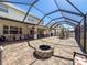 Large screened-in patio with fire pit, tables, and chairs at 10560 Lake Seminole Ter, Seminole, FL 33772
