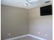 Neutral bedroom with a ceiling fan and a mounted television at 11014 Peking Pl, Tampa, FL 33624