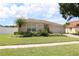 Landscaped single-story home with a well-maintained lawn, mature palm trees, and a convenient two-car garage at 11014 Peking Pl, Tampa, FL 33624