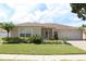 Charming single-story home showcasing manicured lawn, complemented by lush landscaping and an attached two-car garage at 11014 Peking Pl, Tampa, FL 33624