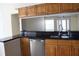 Kitchen showcasing stainless steel appliances, dark countertops, and wooden cabinets with a view to the front entry at 11014 Peking Pl, Tampa, FL 33624
