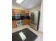A kitchen featuring stainless steel appliances, granite countertops, wooden cabinets and an eat-in bar top at 11014 Peking Pl, Tampa, FL 33624