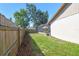 Backyard with a screened-in patio, wooden fence, and lush grass at 1111 Lakemont Dr, Valrico, FL 33594